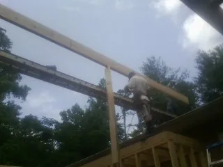 Carpenter setting a ridge beam over a new addition frame — Ice Dam Removal by Roofing Brothers in Rutledge