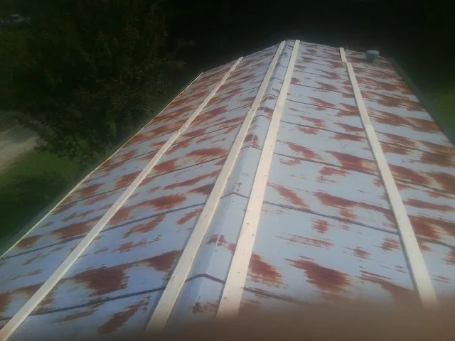 Rusted metal roof panels with new wood purlins before replacement — Storm Damage Roof Repair in Rutledge by Roofing Brothers