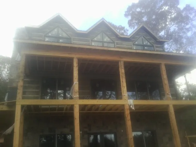 Dormers and porch framing on a large log home under construction — Roof Coating work by our crew in Rutledge