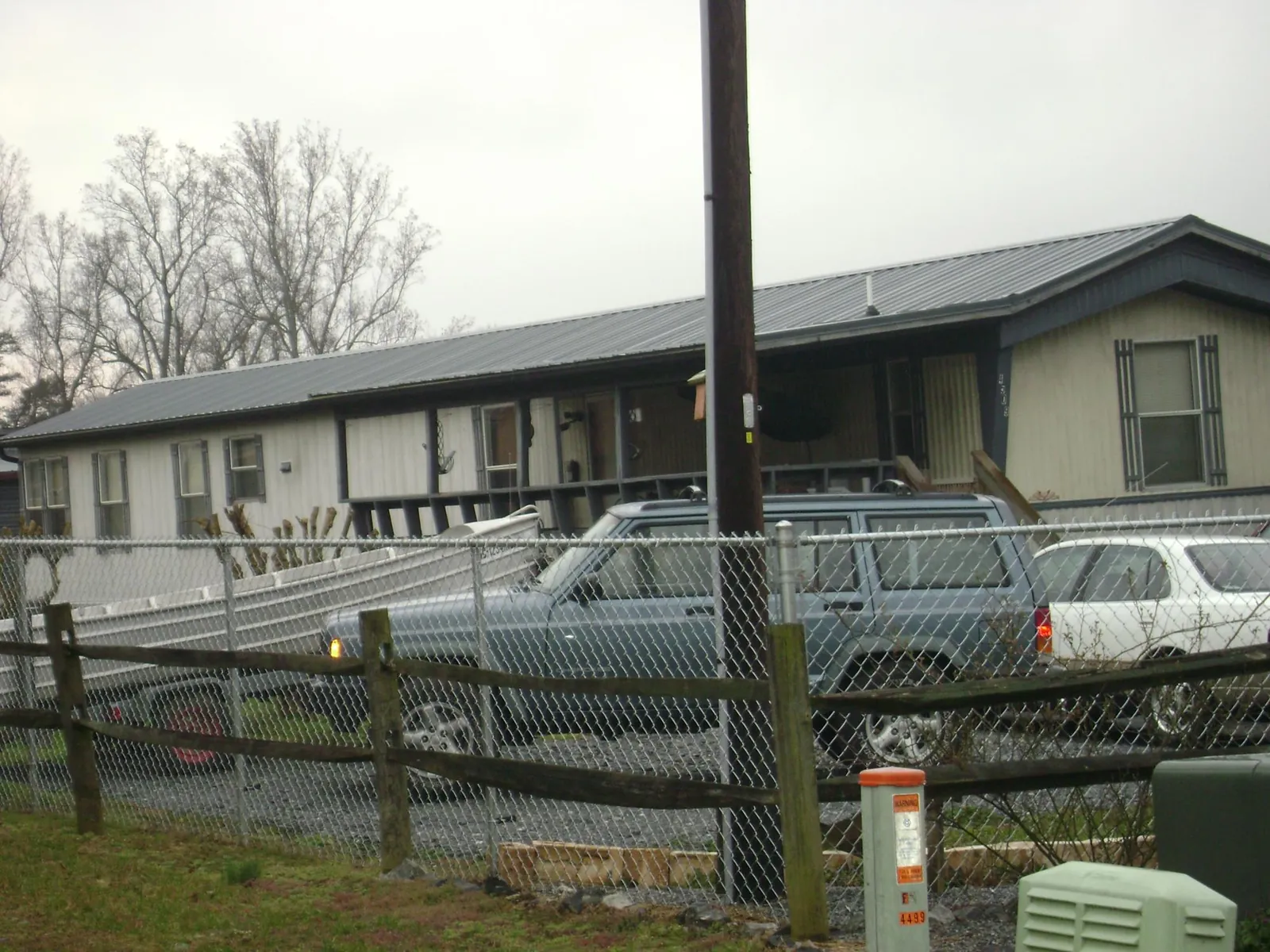 Dark metal roof on a long single story building behind a chain link fence in Rutledge