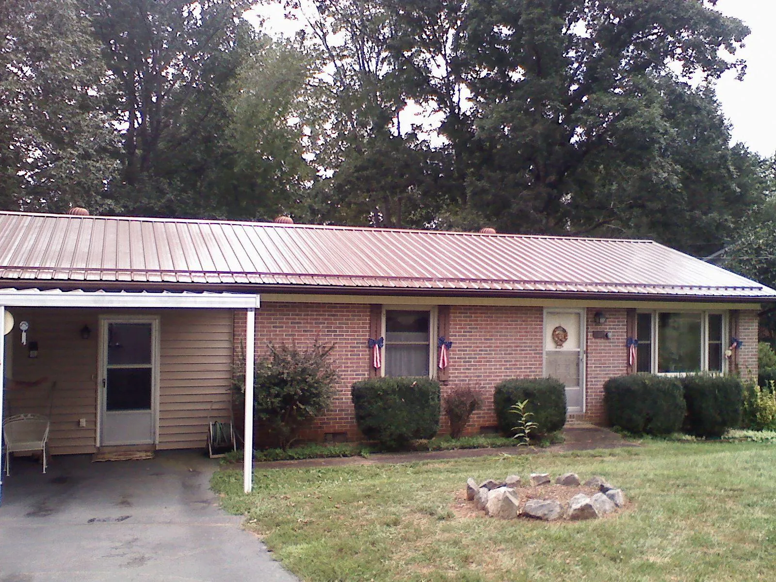 Bronze metal roof and carport on a brick ranch home — Roof Repair work by our crew in Rutledge